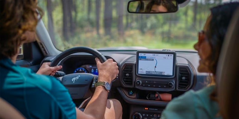 Interior view of a 2024 Ford Bronco Sport with two people talking and enjoying the ride